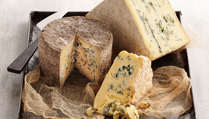 A picture of a range of blue cheeses served on a cheese platter.