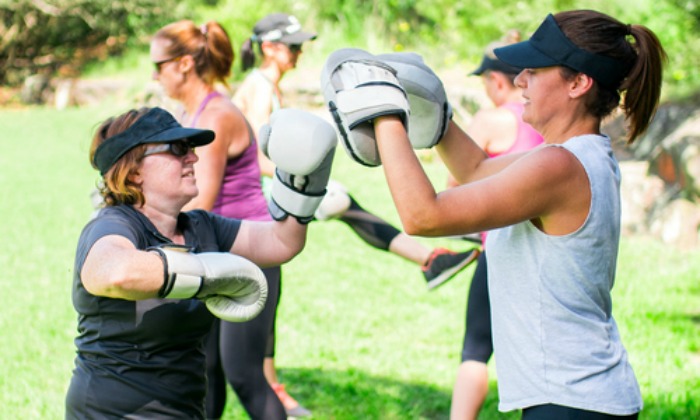 Healthy Bones Action Week for Adults A healthy older woman practices boxing in the park on a sunny day